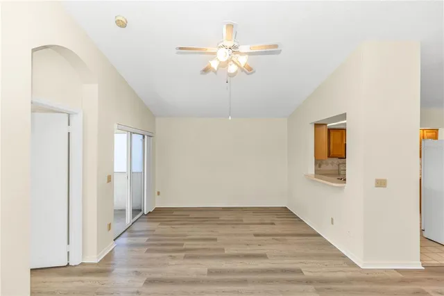 a view of a livingroom with a chandelier fan and wooden floor