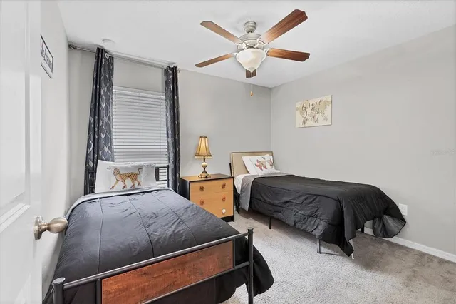 a bedroom with two beds and a ceiling fan