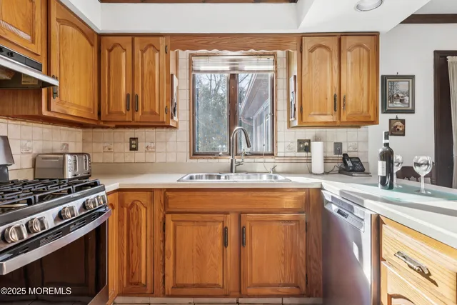a kitchen with stainless steel appliances granite countertop a sink stove and cabinets