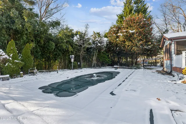 a view of a white house with a big yard and large trees