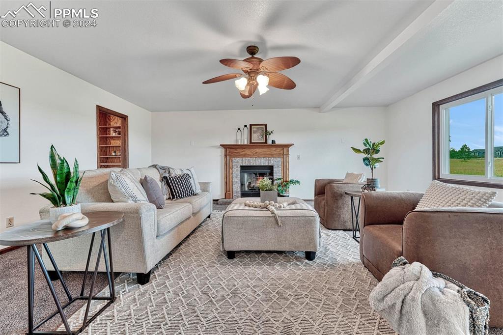 12220 Old Barn Road Elbert, CO 80106 - Photo 12 of 47 a living room with furniture a fireplace and a chandelier