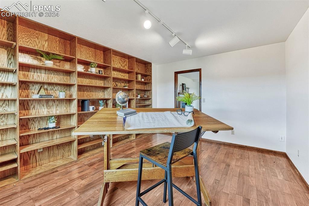 12220 Old Barn Road Elbert, CO 80106 - Photo 14 of 47 a workspace with wooden floor and a bookshelf