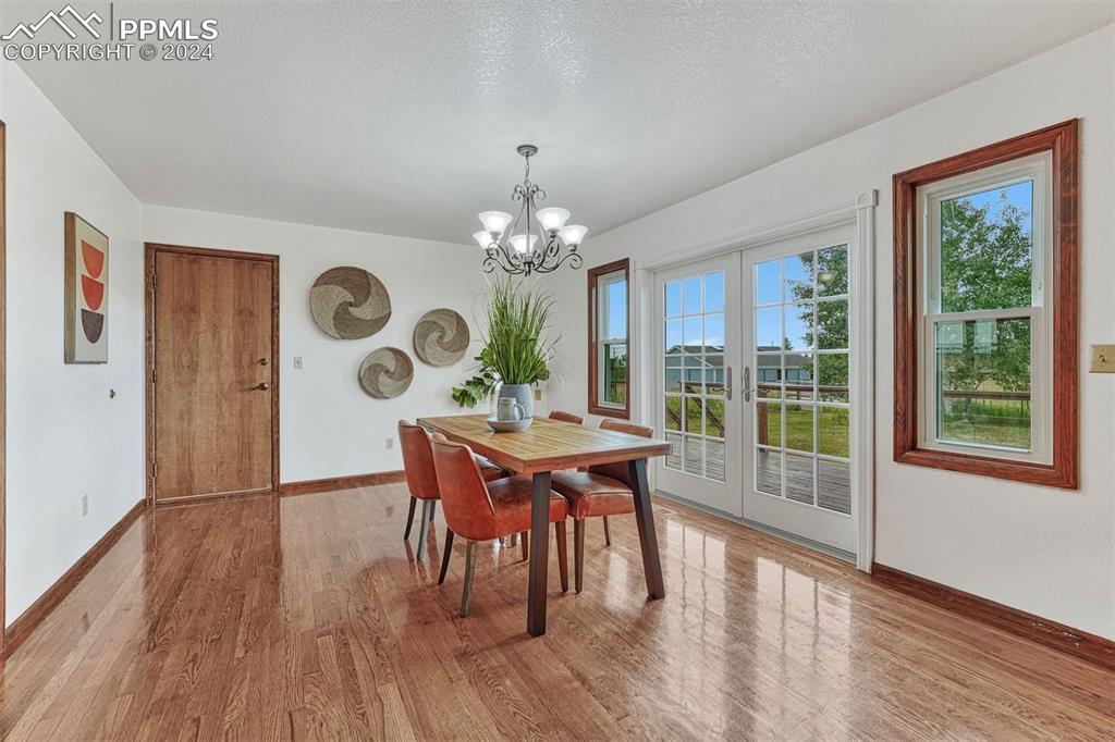 12220 Old Barn Road Elbert, CO 80106 - Photo 16 of 47 a dining room with furniture a large window and wooden floor