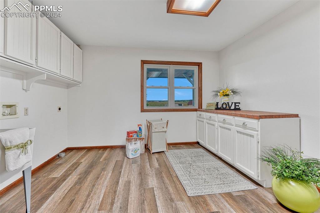 12220 Old Barn Road Elbert, CO 80106 - Photo 18 of 47 a kitchen that has a lot of white cabinets and wooden floor