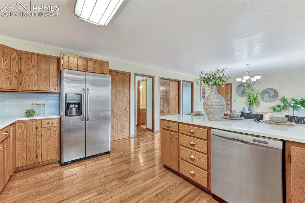12220 Old Barn Road Elbert, CO 80106 - Photo 26 of 47 a kitchen with stainless steel appliances granite countertop a refrigerator a sink dishwasher a stove and white countertops with wooden floor