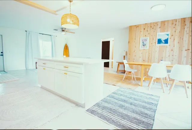 a living room with stainless steel appliances furniture and a chandelier
