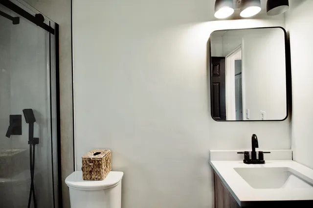 a bathroom with a toilet sink and mirror