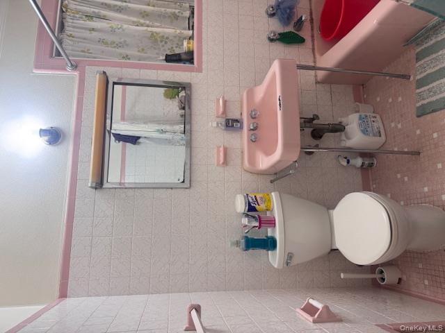 91-33 78th Street Queens, NY 11421 - Photo 19 of 26 a bathroom with a toilet sink and mirror