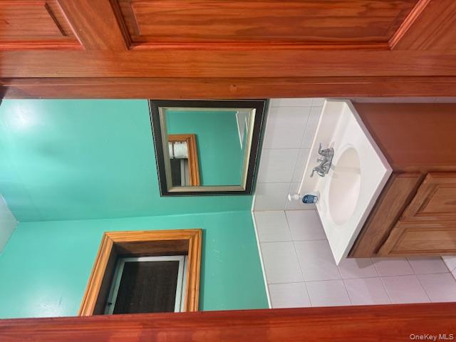 91-33 78th Street Queens, NY 11421 - Photo 10 of 26 a bathroom with a sink and a mirror