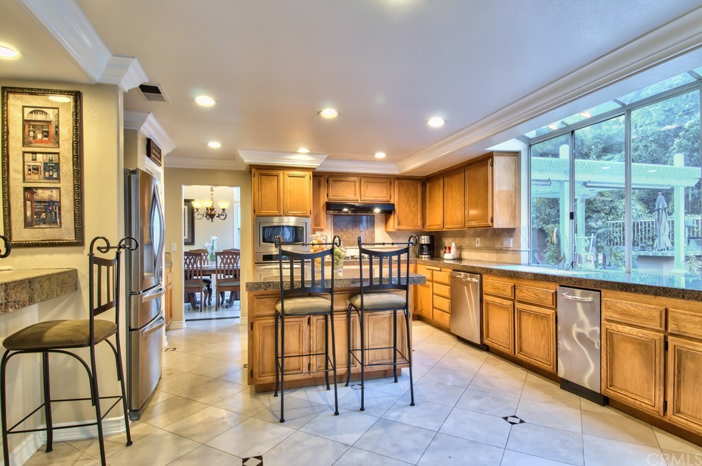 4224 San Ramon Drive Corona, CA 92882 - Photo 10 of 63 Inspire your inner chef in this large kitchen featuring extensive granite and stone surfaces, stainless steel appliances, including a trash compactor, and an oversized island with casual seating.