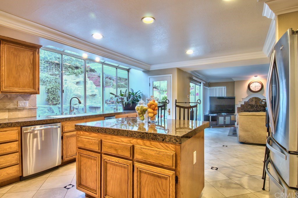 4224 San Ramon Drive Corona, CA 92882 - Photo 12 of 63 The great room of the kitchen and the family room has windows spanning the length of the entire rear wing, allowing for sweeping views of the backyard and a profusion of natural light to pour into the home.