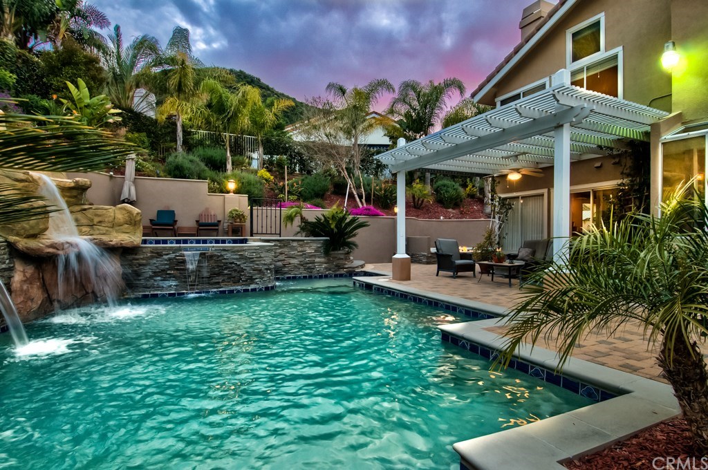 4224 San Ramon Drive Corona, CA 92882 - Photo 3 of 63 The stunning entertainment style of this remarkable backyard will win you over! It's anchored by a custom Pebble-Tech pool with multiple waterfalls, an oversized spa with decking, two large covered structures, a gas fire pit with a built-in seating area, a deck with city lights view, professional landscaping and lighting and pavers through out that will render this home its very own resort