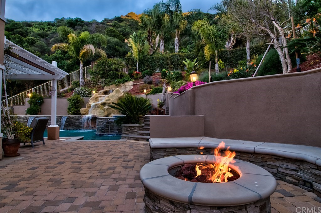 4224 San Ramon Drive Corona, CA 92882 - Photo 4 of 63 The natural gas fireplace has circular areas and pavers all around.
