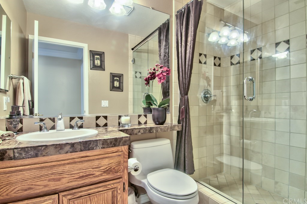4224 San Ramon Drive Corona, CA 92882 - Photo 32 of 63 The downstairs bathroom has extensive use of Marble and Limestone stones and a thick shower door.
