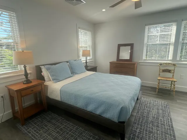 a bedroom with a bed and a lamp on dresser