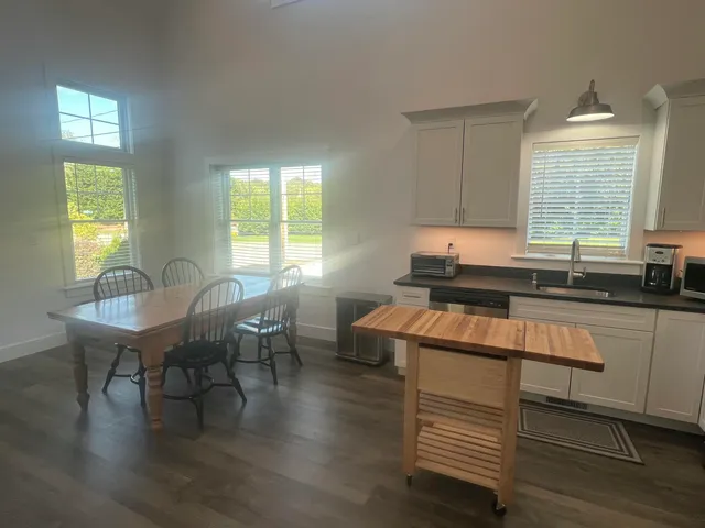 a kitchen with a table chairs and wooden floor