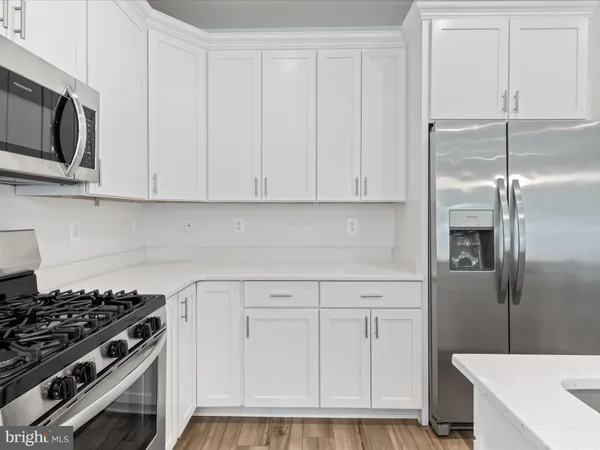 a view of kitchen with wooden floor electronic appliances and window