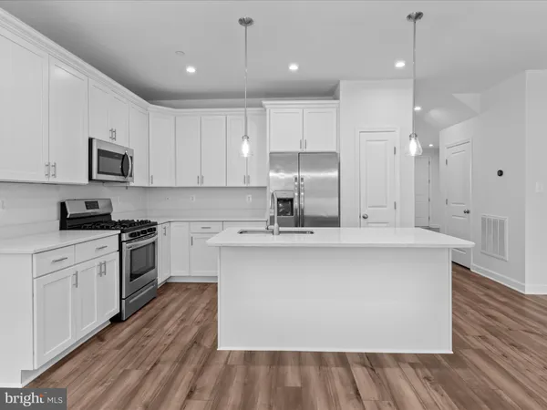 a view of a kitchen with a lot of cabinets and wooden floor
