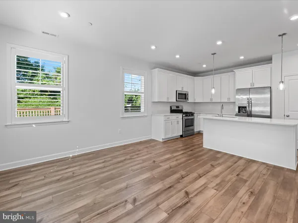 a view of empty room with wooden floor and fireplace