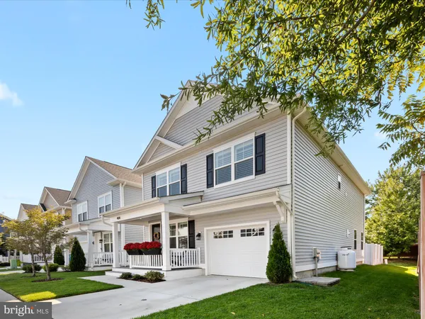 a view of an empty room with wooden floor and stairs