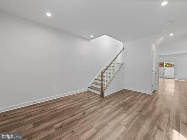 an empty room with wooden floor and fireplace