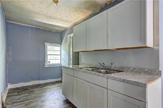 a kitchen with a sink cabinets and wooden floor