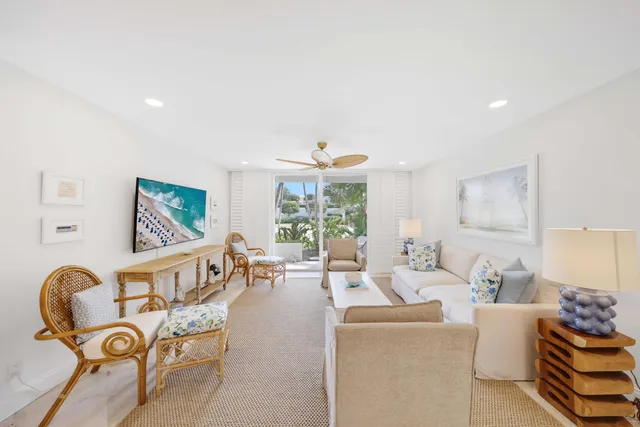 a living room with furniture a table and large windows
