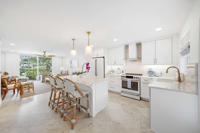 a kitchen with granite countertop a sink stainless steel appliances and white cabinets