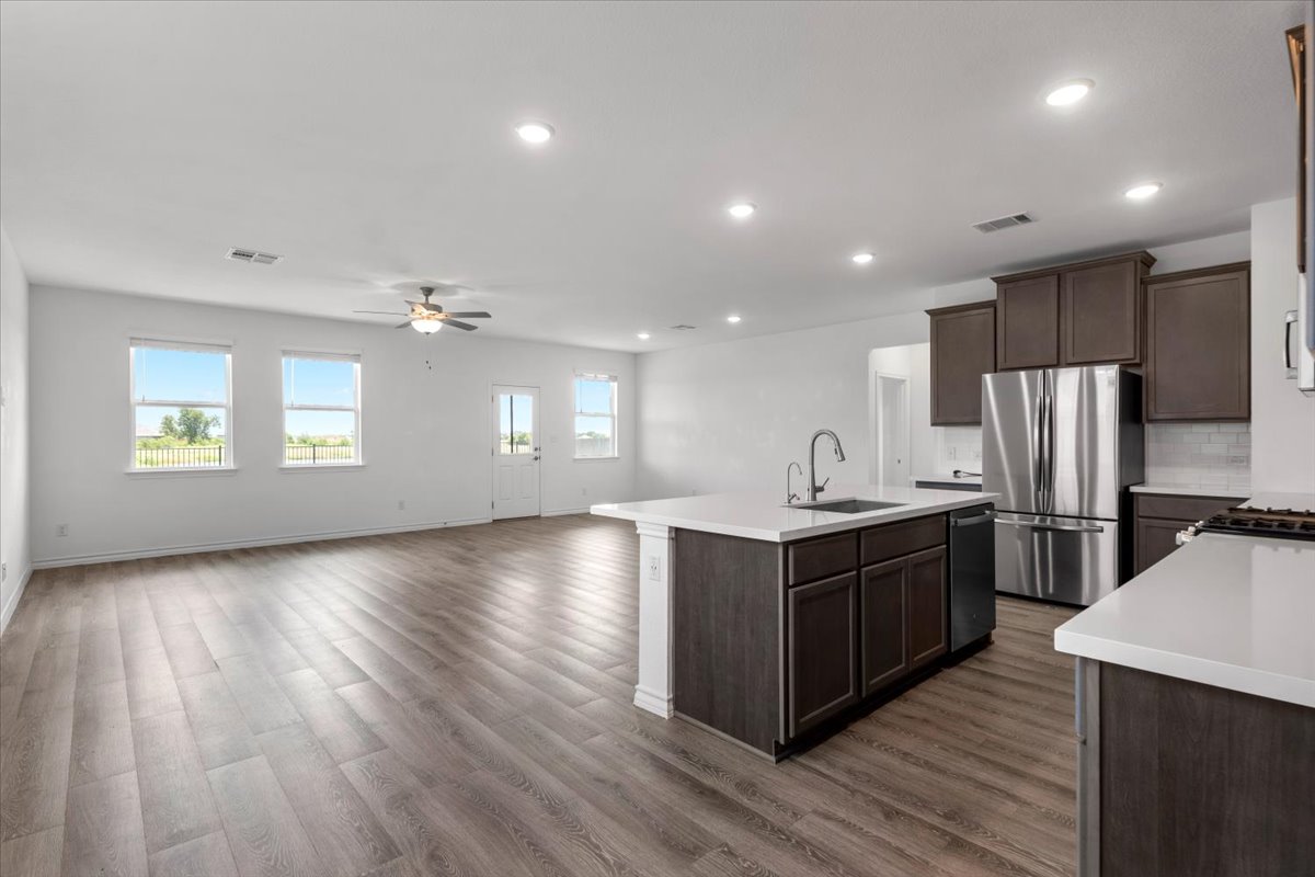500 Stinchcomb Road Hutto, TX 78634 - Photo 19 of 37 An open concept living area seamlessly blends the living room and kitchen, illuminated by abundant natural light.