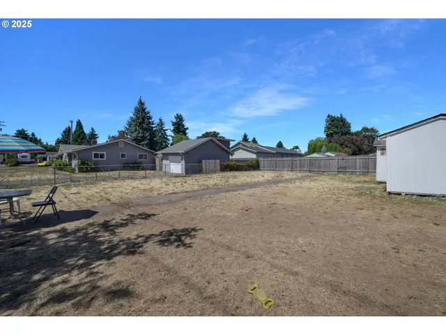 a view of a patio with table and chairs and a barbeque