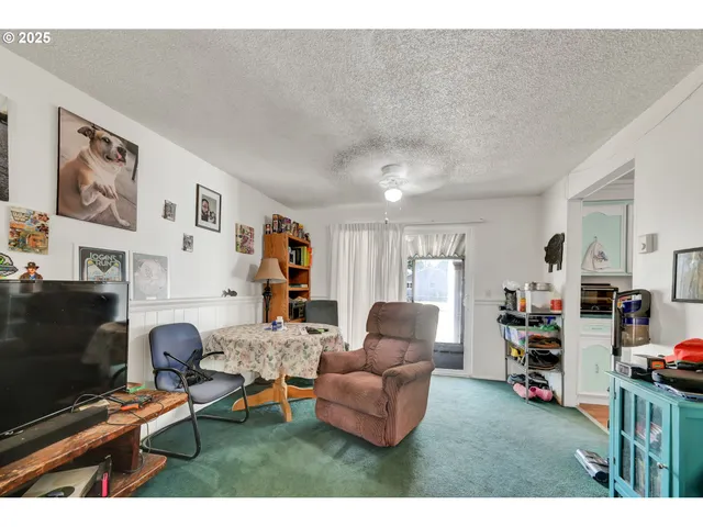 a living room with furniture a flat screen tv and a table