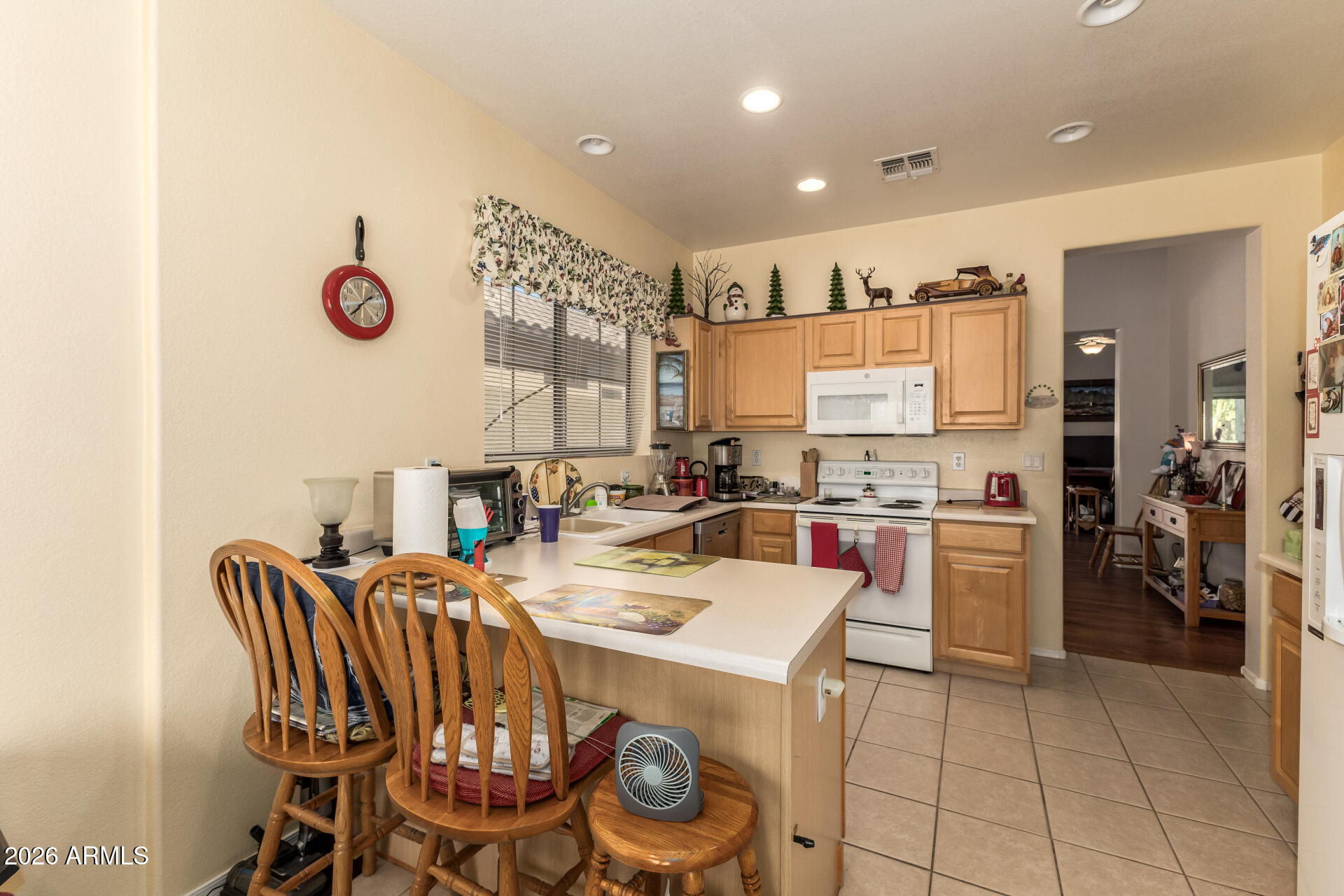 3448 West Webster Court Anthem, AZ 85086 - Photo 4 of 40 a kitchen with a dining table chairs sink and white appliances