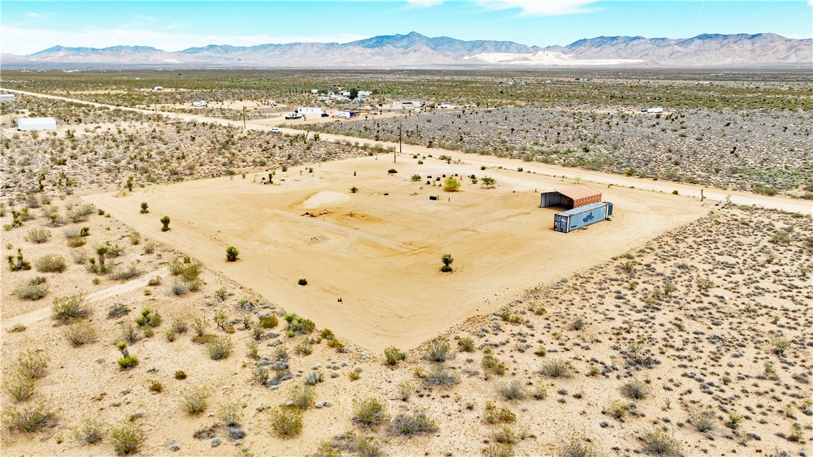 5649 Davis Road Golden Valley, AZ 86413 - Photo 13 of 24 Expansive desert lot featuring a cleared building pad and a metal-roofed structure