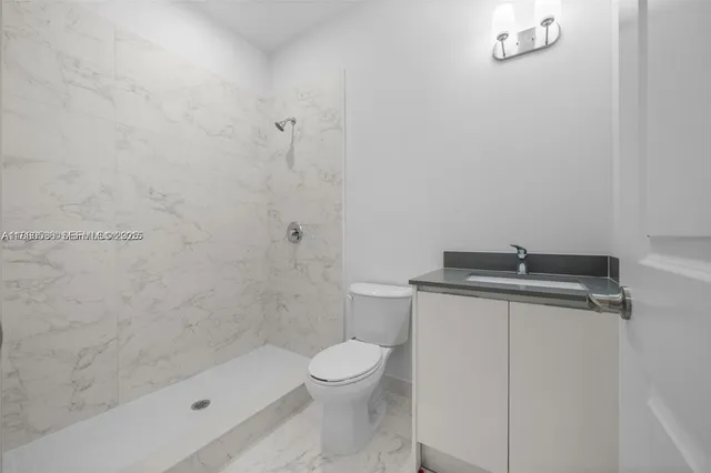 a white toilet sitting next to a shower