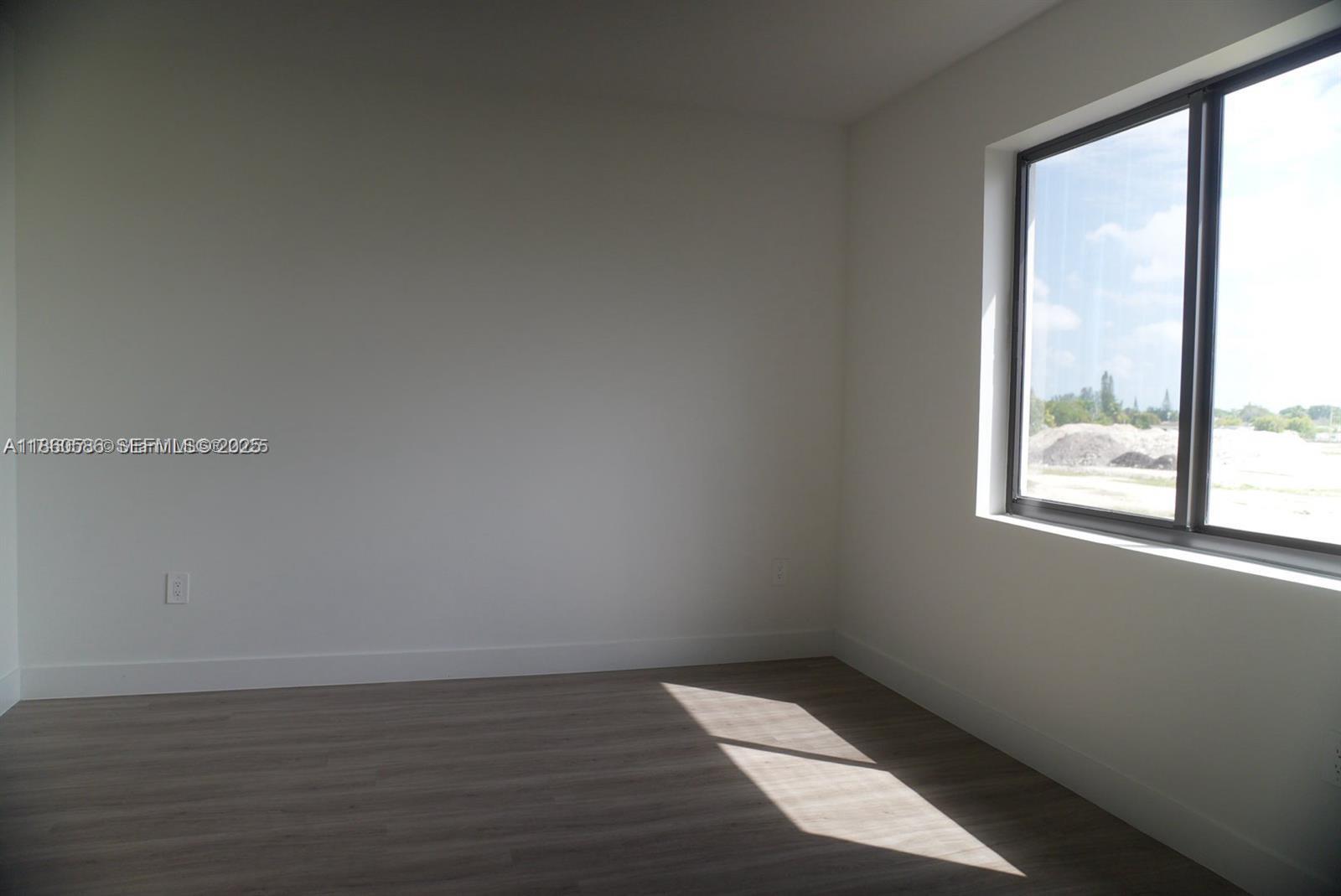 18970 Southwest 345th Terrace Homestead, FL 33034 - Photo 13 of 20 an empty room with wooden floor and windows