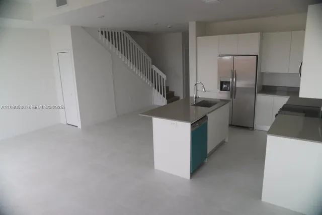 a kitchen with a stove a refrigerator and a sink