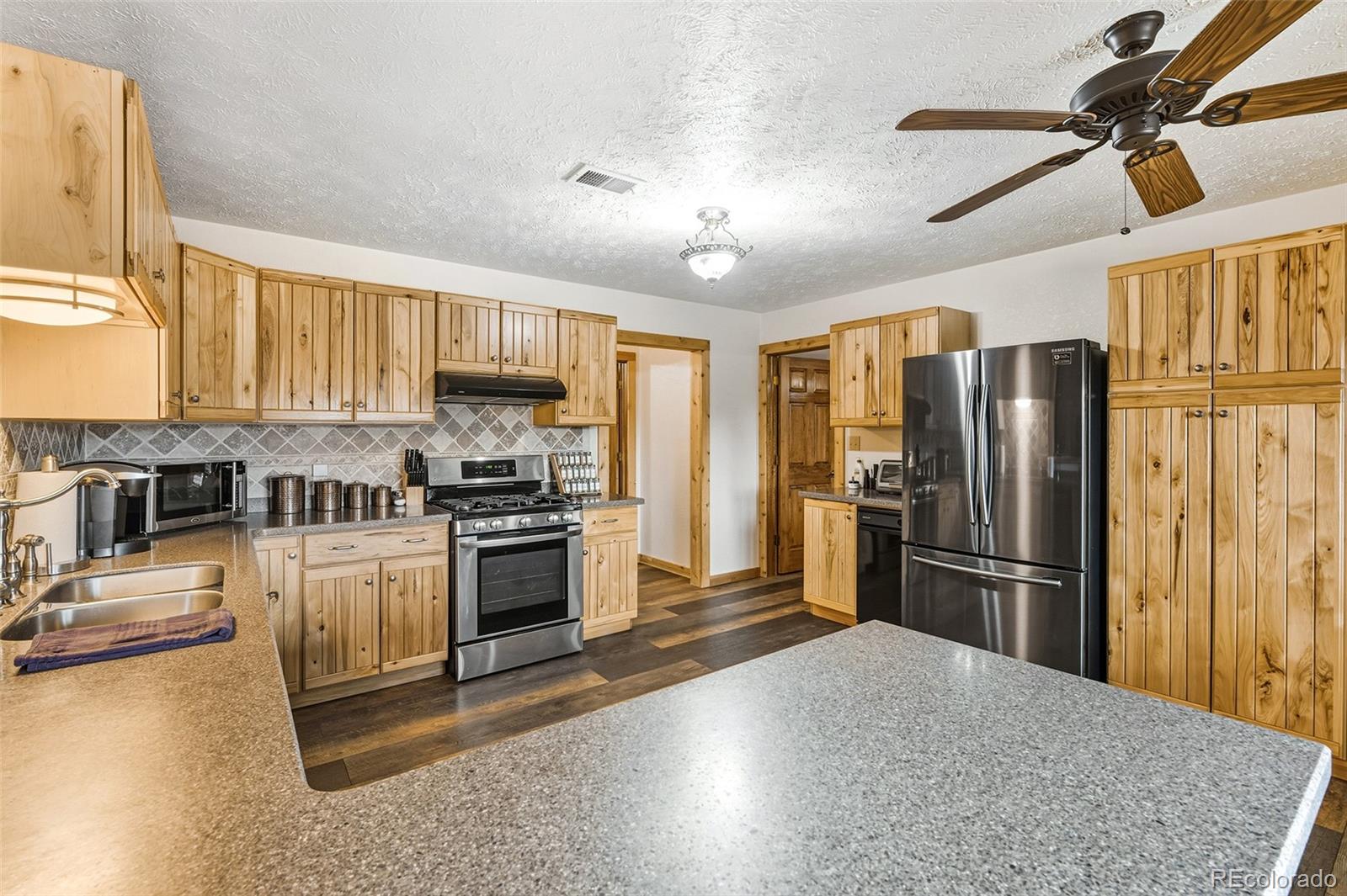 111 Twinkle Road Guffey, CO 80820 - Photo 18 of 39 a kitchen with granite countertop a refrigerator stove top oven and sink