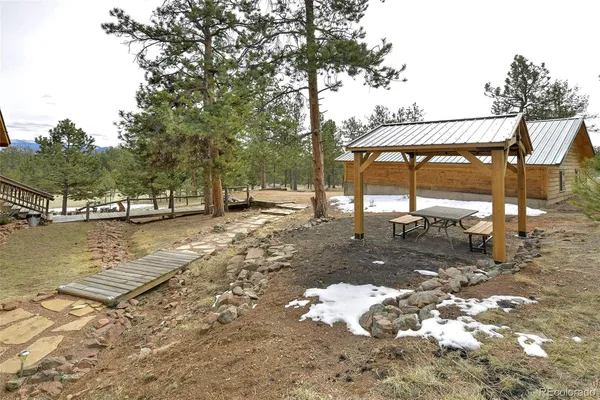 a view of a lake with a table and chairs under an umbrella