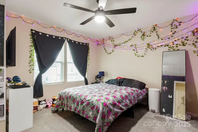 a bedroom with a bed window and a flat tv screen