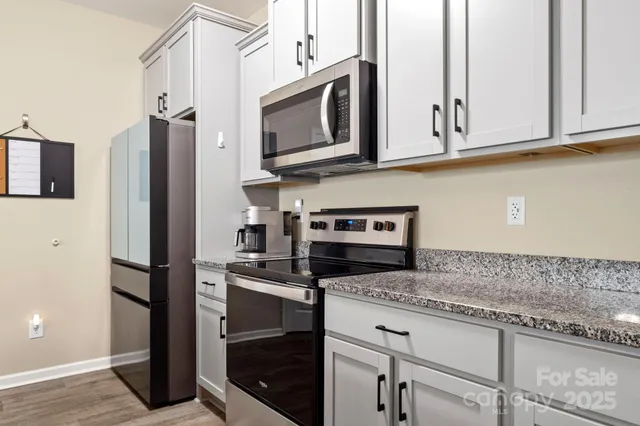 a kitchen with stainless steel appliances granite countertop a stove microwave and refrigerator