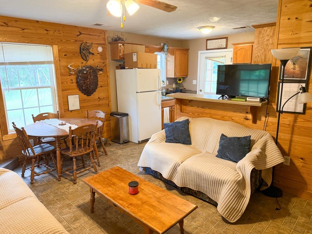 0 Poplar Grove Cemetery Road Henning, TN 38041 - Photo 8 of 40 Open-concept living space featuring wood-finish wall paneling, a ceiling fan, and tile flooring