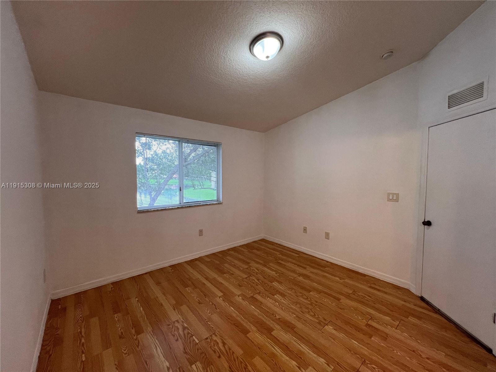 1261 Southeast 31st Court, Unit 20453 Homestead, FL 33035 - Photo 11 of 15 an empty room with wooden floor and windows