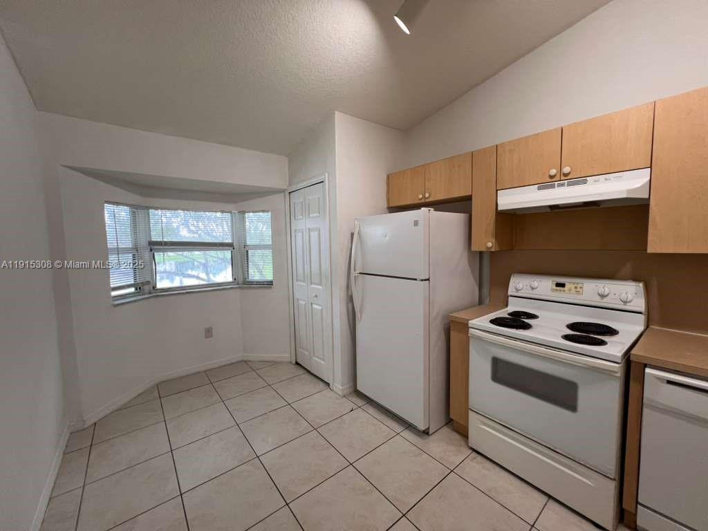 1261 Southeast 31st Court, Unit 20453 Homestead, FL 33035 - Photo 2 of 15 a kitchen with a stove and a refrigerator