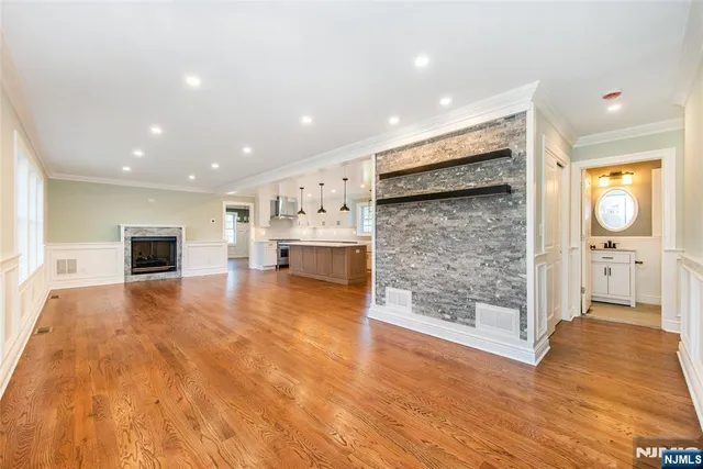 a large white kitchen with kitchen island a sink a stove and white cabinets