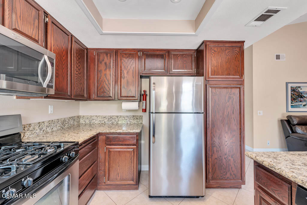 13644 Bear Valley Road Moorpark, CA 93021 - Photo 9 of 29 a kitchen with stainless steel appliances granite countertop a refrigerator stove and microwave