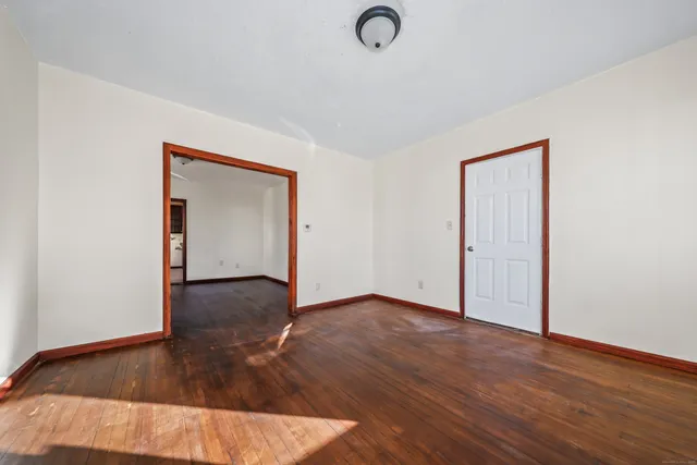 an empty room with wooden floor and closet