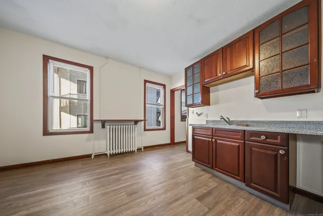 an empty room with wooden floor and cabinet