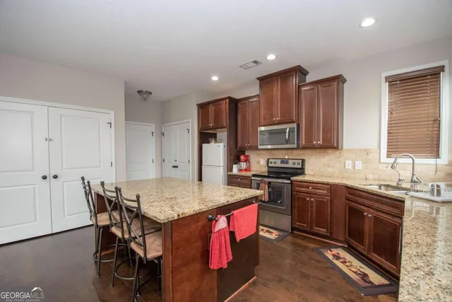 a kitchen with stainless steel appliances granite countertop a stove top oven a sink and dishwasher
