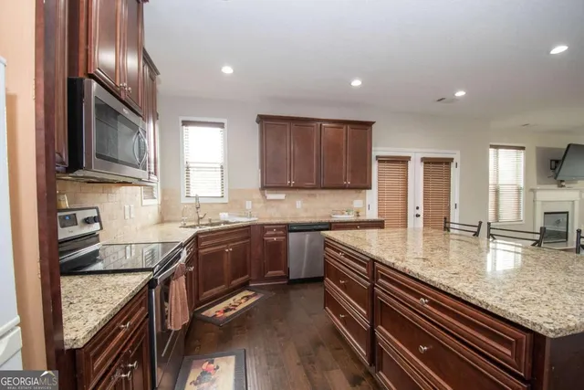 a kitchen with stainless steel appliances granite countertop a sink stove and refrigerator