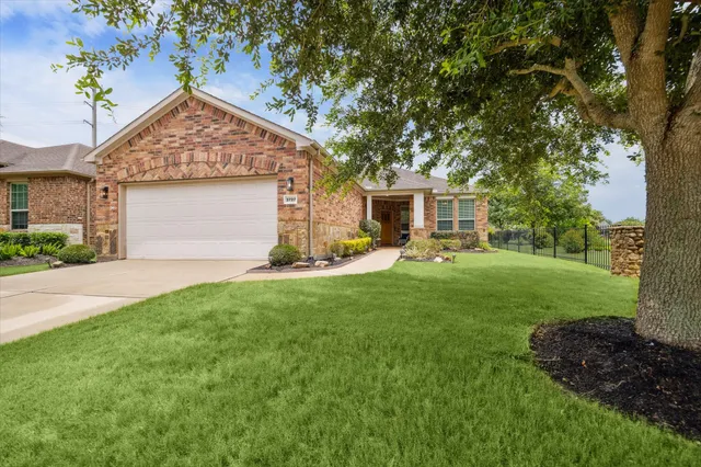 a view of a house with backyard and a tree